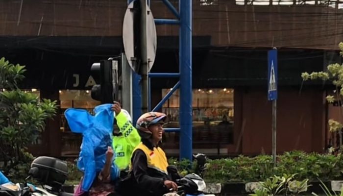 Polantas Polres Malang Bagikan Jas Hujan ke Pengendara di Tengah Hujan Deras